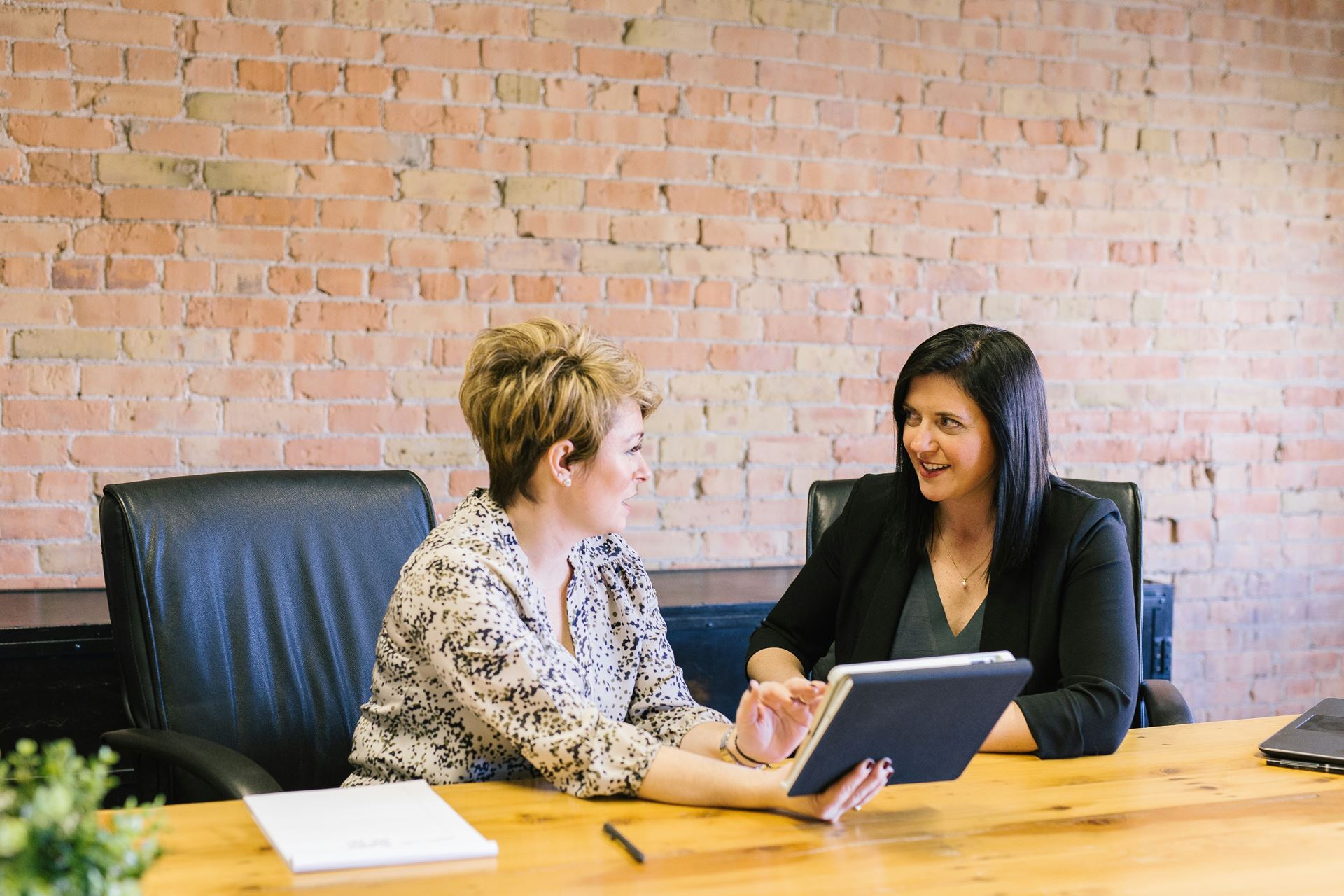 two women talking sat down at a table