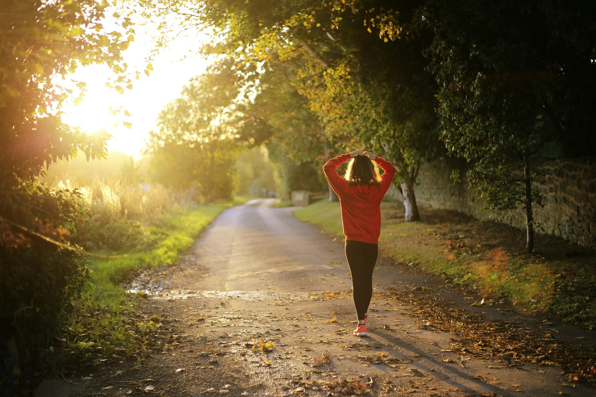 woman walking along a country path with sunlight