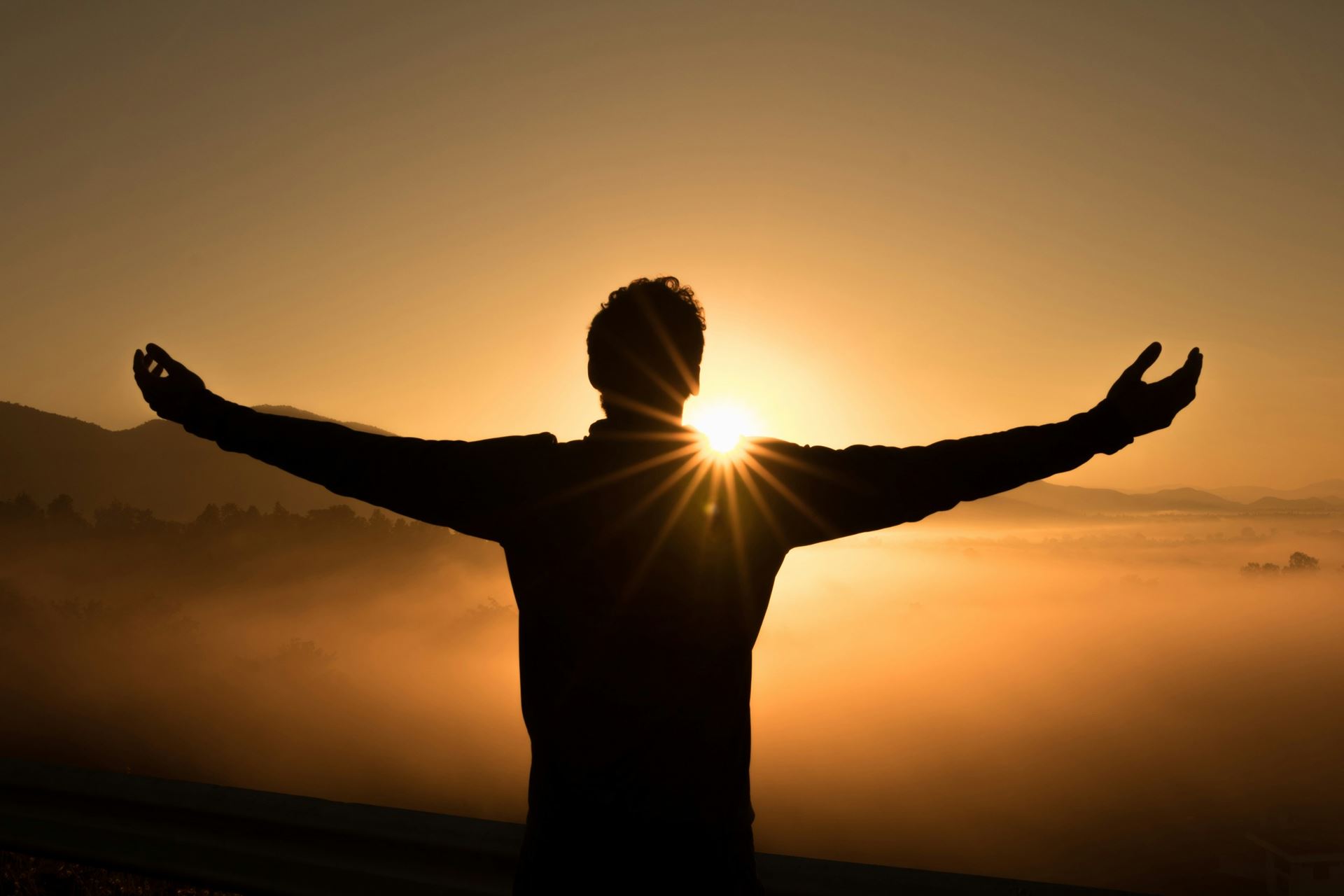 man standing in front of a sunset